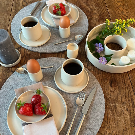 beigefarbenes handgedrehtes Mlichkännchen aus Steinzeugton auf einem gedeckten Frühstückstisch