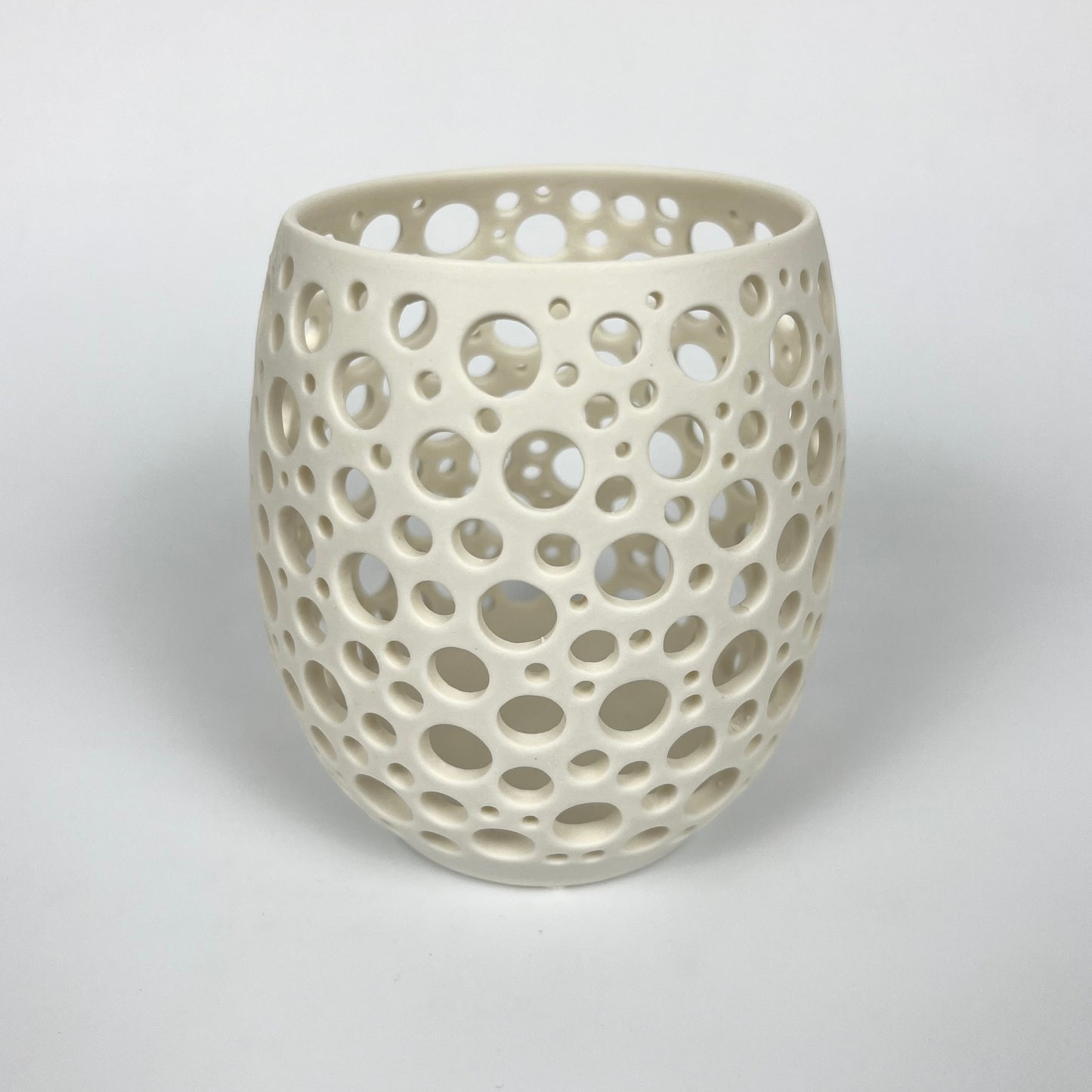 großes weißes handgedrehtes Porzellanlicht mit vielen sehr eng liegenden unterschiedlich großen handgestochenen Löchern