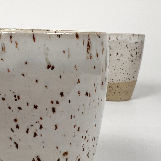 zwei kleiner handgedrehte Becher aus Steinzeugton mit Basaltspots, einer sehr nah