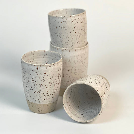 vier große handgedrehte Becher aus Steinzeugton mit Basaltspots, gestapelt und liegend