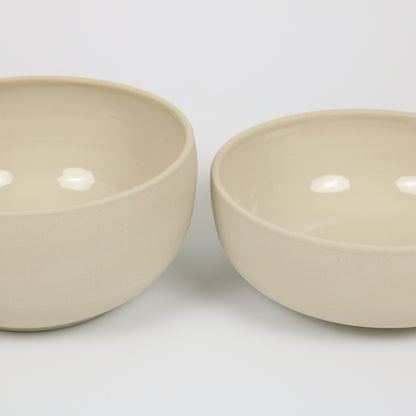 zwei große beigefarbene handgedrehte Bowls aus Steinzeugton, unterschiedlich hoch