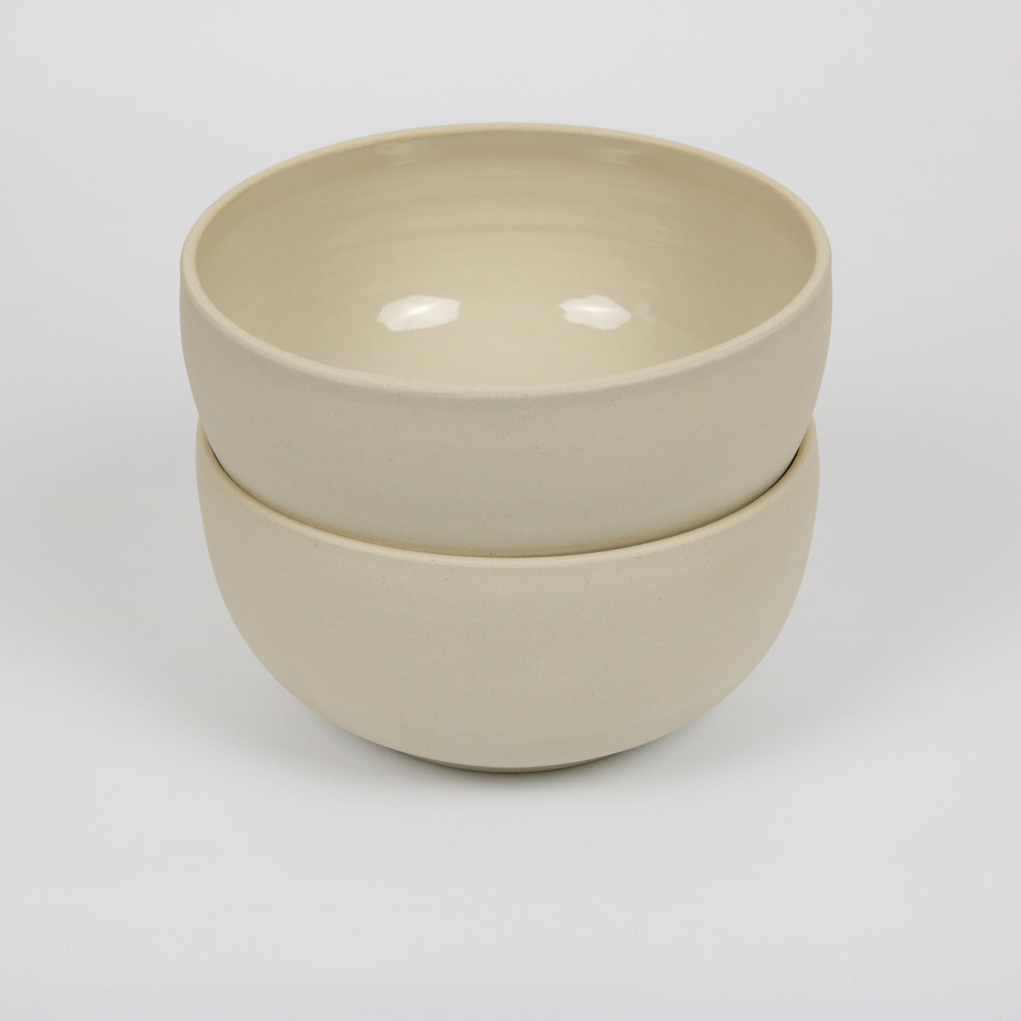 zwei große hohe beigefarbene handgedrehte Bowls aus Steinzeugton, gestapelt