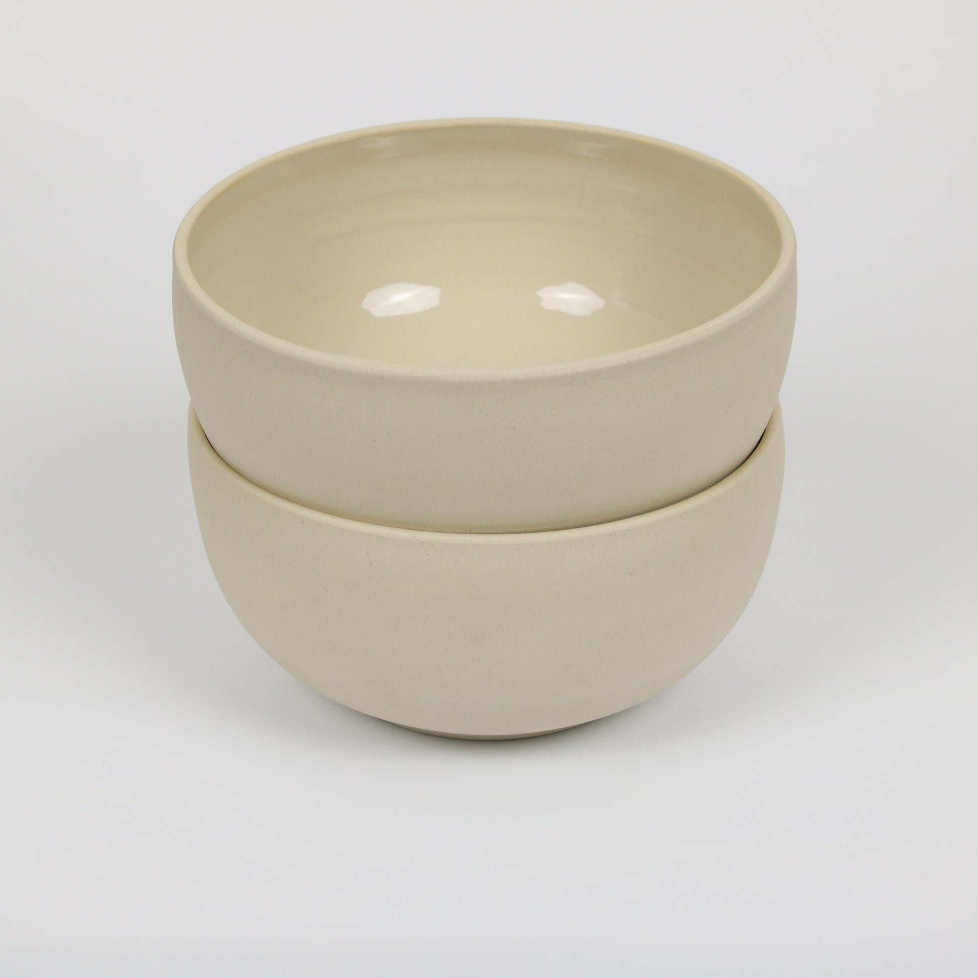 zwei große hohe beigefarbene handgedrehte Bowls aus Steinzeugton, gestapelt