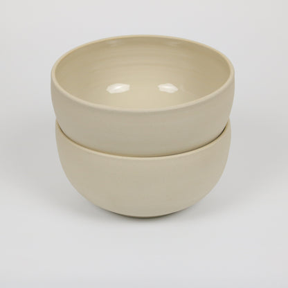 zwei große hohe beigefarbene handgedrehte Bowls aus Steinzeugton, gestapelt