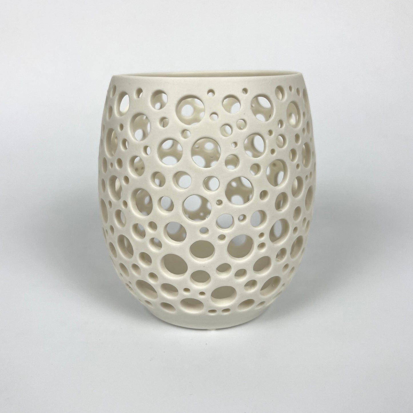 großes weißes handgedrehtes Porzellanlicht mit vielen sehr eng liegenden unterschiedlich großen handgestochenen Löchern