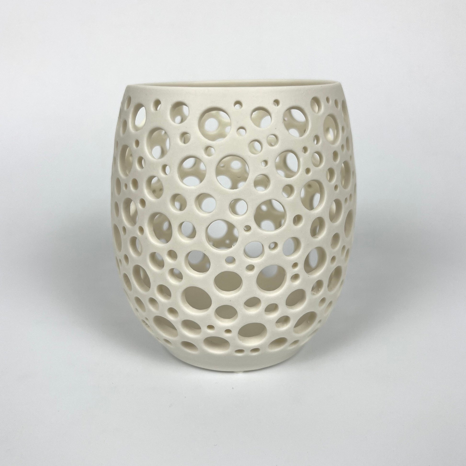 großes weißes handgedrehtes Porzellanlicht mit vielen sehr eng liegenden unterschiedlich großen handgestochenen Löchern