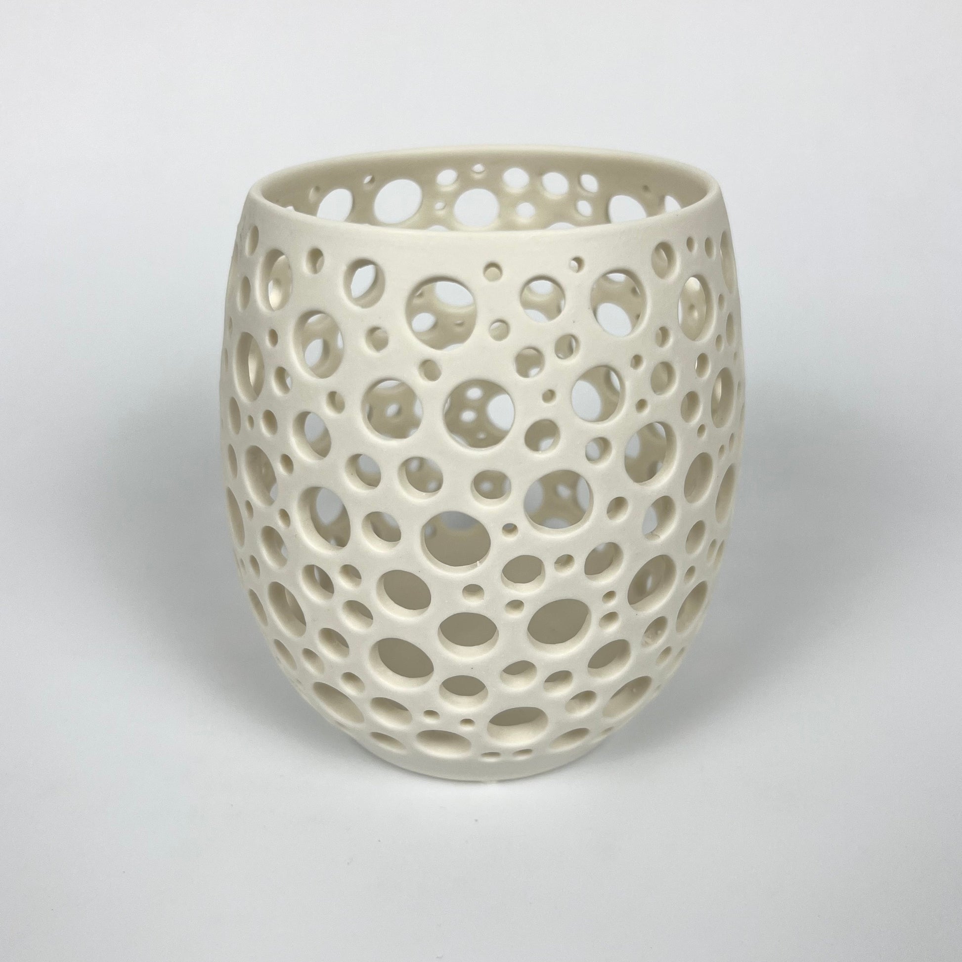 großes weißes handgedrehtes Porzellanlicht mit vielen sehr eng liegenden unterschiedlich großen handgestochenen Löchern